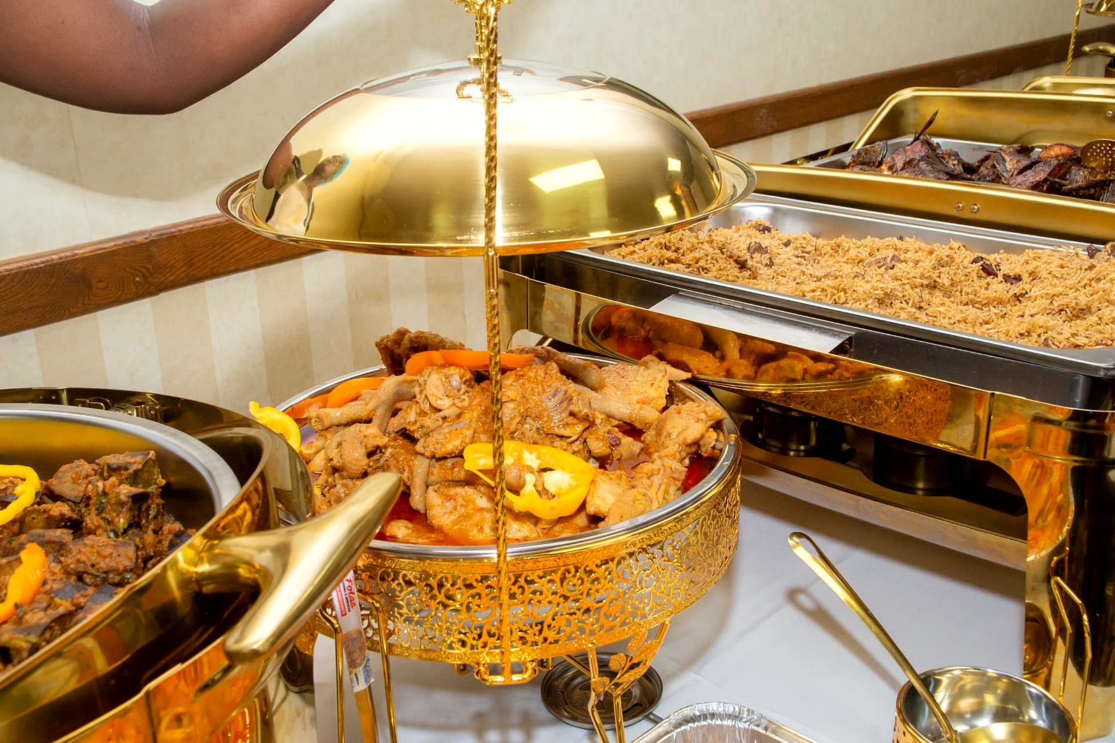 Chicken wet fry with peppers beside spiced pilau rice in gold chafing dishes, North York catering