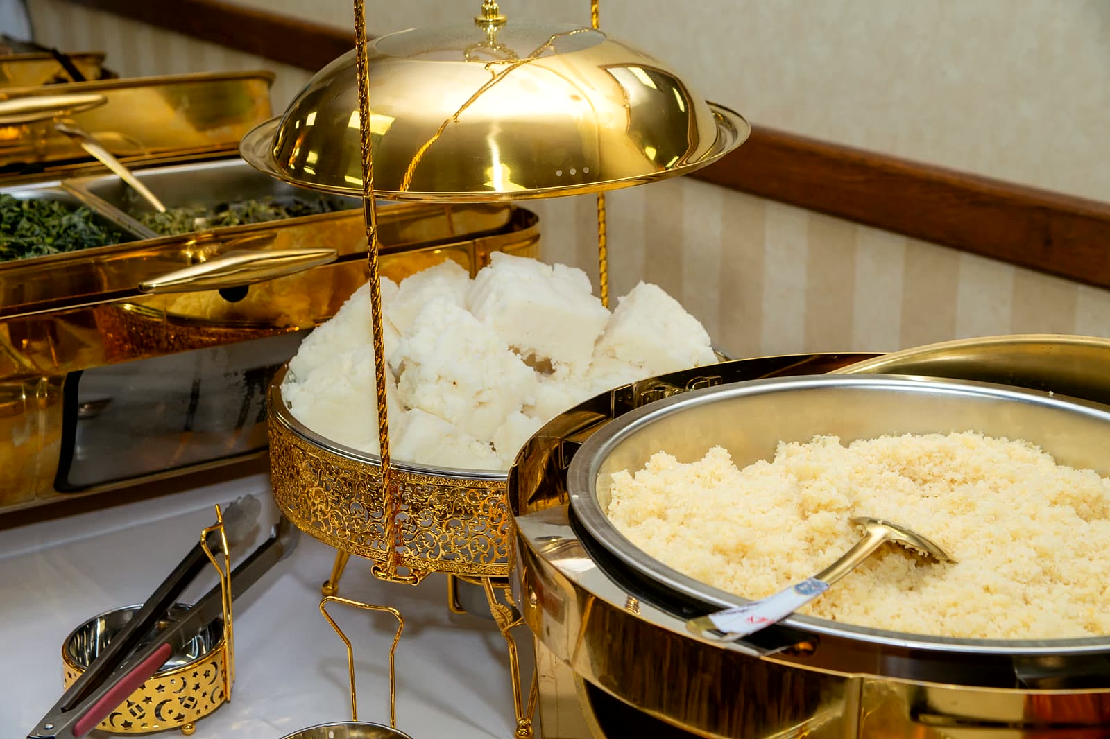 Ugali, steamed rice and sautéed greens presented in gold domed chafing dishes at a Toronto event