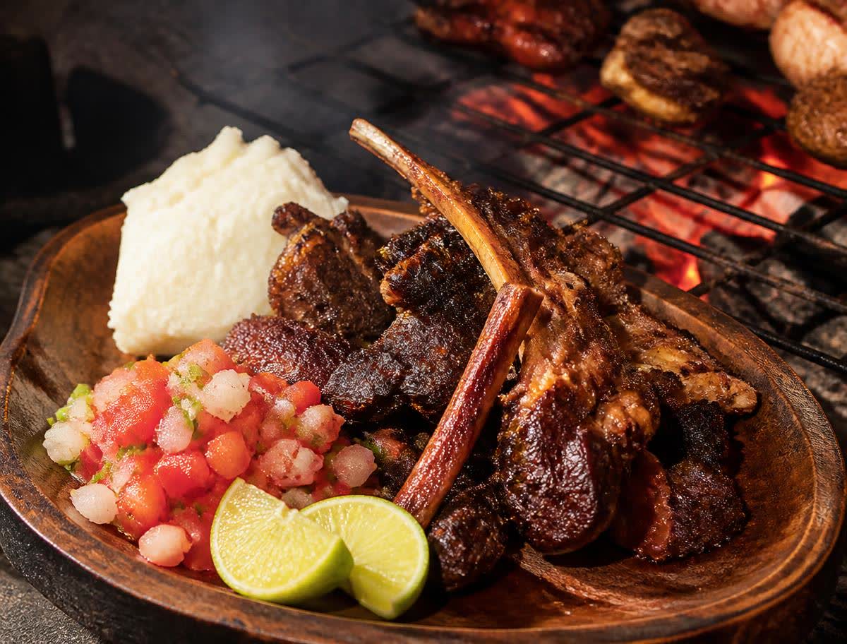 Charcoal slow-roasted goat meat served with fresh tomato-onion salad and lime by M&N Luxe Events catering